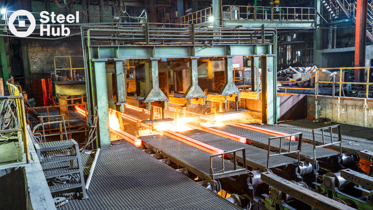 Steel manufacturing facility with glowing hot steel moving through an industrial rolling mill production line.